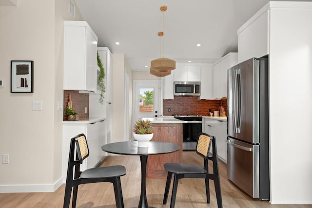3704 Munson St Unit 1, Austin, TX 78721 - kitchen featuring appliances with stainless steel finishes, a center island, light wood-style flooring, tasteful backsplash, and recessed lighting