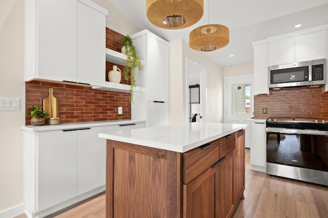 3704 Munson St Unit 1, Austin, TX 78721 - kitchen with open shelves, appliances with stainless steel finishes, backsplash, light countertops, and white cabinets