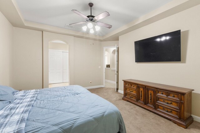 15325 Interlachen Dr, Austin, TX 78717 - bedroom with light colored carpet, arched walkways, a raised ceiling, and ceiling fan
