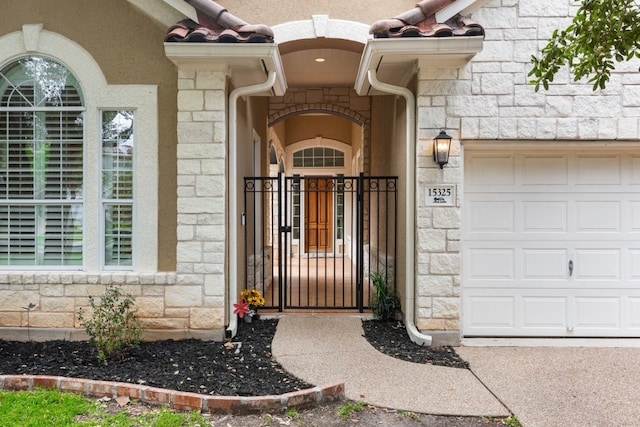 15325 Interlachen Dr, Austin, TX 78717 - doorway to property featuring stone siding, an attached garage, a gate, and stucco siding