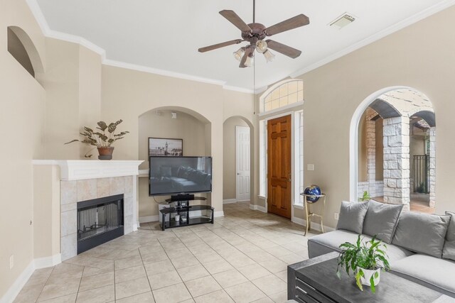 15325 Interlachen Dr, Austin, TX 78717 - living area featuring a ceiling fan, ornamental molding, arched walkways, light tile patterned flooring, and a tiled fireplace