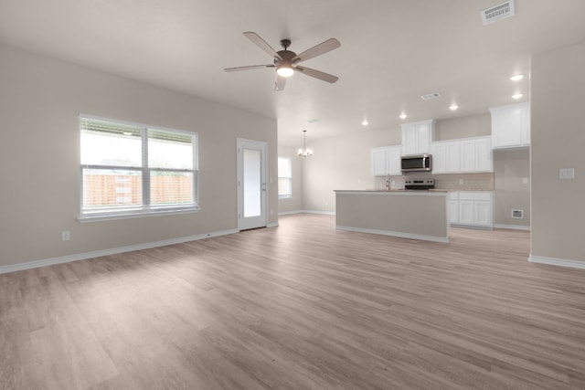 817 Coke Rd, Burnet, TX 78611 - unfurnished living room featuring a chandelier, a ceiling fan, light wood-style flooring, and recessed lighting