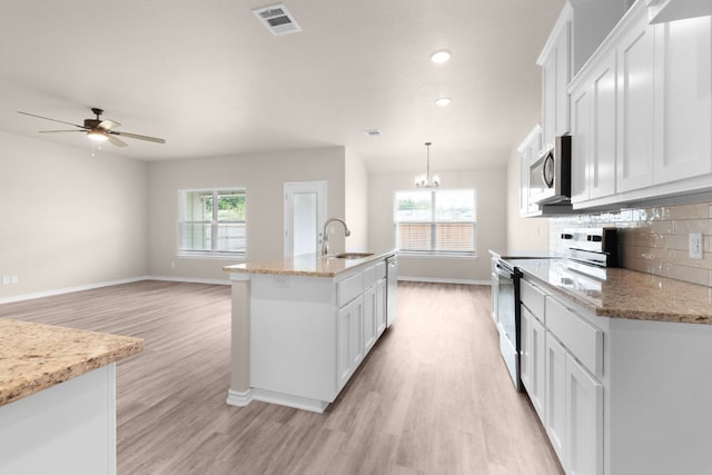 817 Coke Rd, Burnet, TX 78611 - kitchen with stainless steel appliances, light wood-style floors, white cabinetry, healthy amount of natural light, and recessed lighting