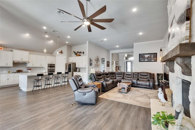 2817 Mossy Springs Dr, Leander, TX 78641 - living room featuring ceiling fan, a stone fireplace, light wood finished floors, recessed lighting, and lofted ceiling