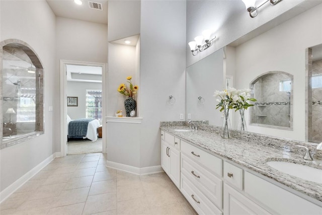 2817 Mossy Springs Dr, Leander, TX 78641 - bathroom with double vanity, a tile shower, connected bathroom, tile patterned flooring, and recessed lighting