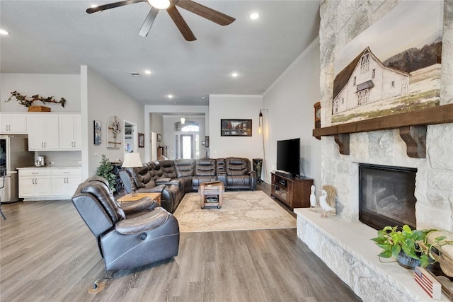2817 Mossy Springs Dr, Leander, TX 78641 - living room with a ceiling fan, wood finished floors, a stone fireplace, crown molding, and recessed lighting