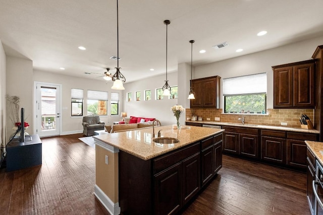 29 Prestonwood Cir, Lakeway, TX 78734 - kitchen with recessed lighting, tasteful backsplash, a center island with sink, light stone countertops, and decorative light fixtures