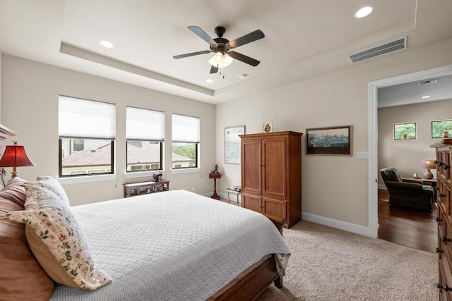 29 Prestonwood Cir, Lakeway, TX 78734 - bedroom featuring multiple windows, recessed lighting, light carpet, a tray ceiling, and a ceiling fan