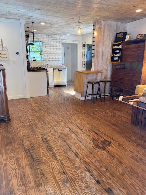 1305 Salina St Unit 1, Austin, TX 78702 - kitchen with wood finished floors, dishwasher, white cabinetry, wood ceiling, and a breakfast bar area