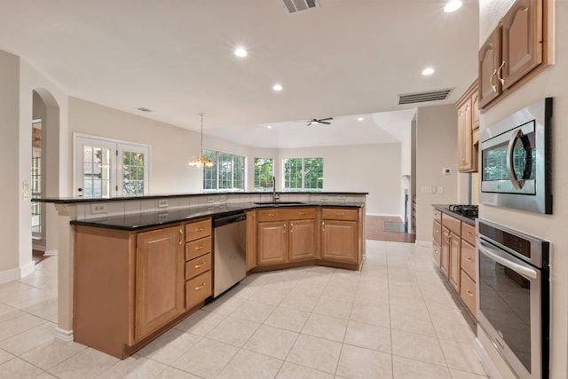 11208 Cedarcliffe Dr, Austin, TX 78750 - kitchen with stainless steel appliances, recessed lighting, light tile patterned floors, a large island with sink, and arched walkways