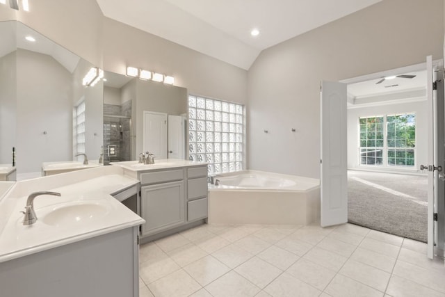 11208 Cedarcliffe Dr, Austin, TX 78750 - full bath with lofted ceiling, two vanities, a garden tub, tile patterned flooring, and a shower stall