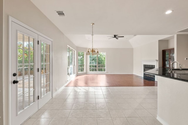 11208 Cedarcliffe Dr, Austin, TX 78750 - kitchen with light tile patterned floors, a tile fireplace, dark countertops, a chandelier, and ceiling fan
