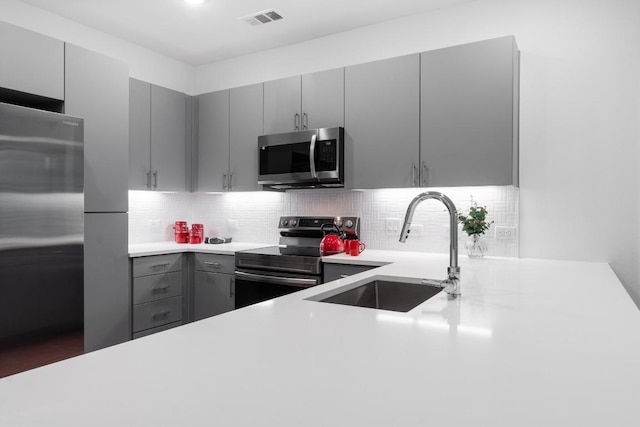 4801 Springdale Dr Unit 2010, Austin, TX 78723 - kitchen with appliances with stainless steel finishes, gray cabinetry, light countertops, and backsplash