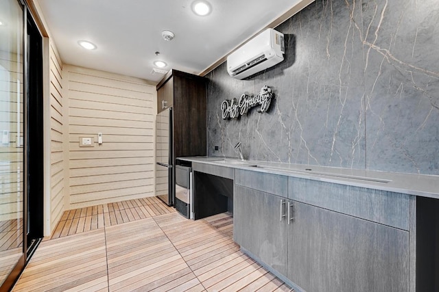 4801 Springdale Dr Unit 2010, Austin, TX 78723 - kitchen with a wall unit AC, light tile patterned flooring, recessed lighting, light countertops, and fridge