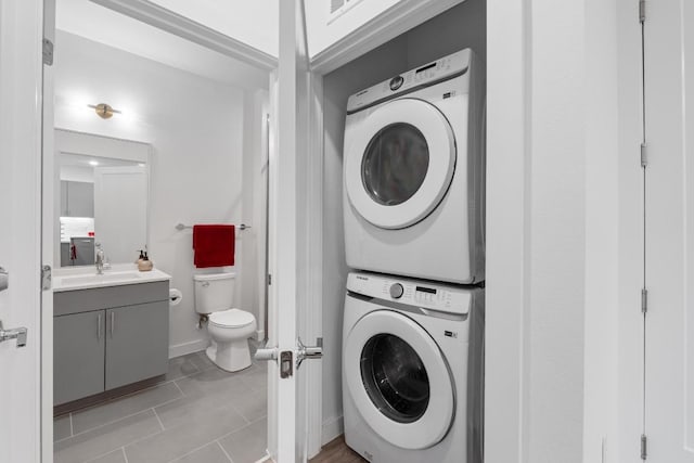 4801 Springdale Dr Unit 2010, Austin, TX 78723 - laundry area featuring stacked washer and clothes dryer and light tile patterned floors