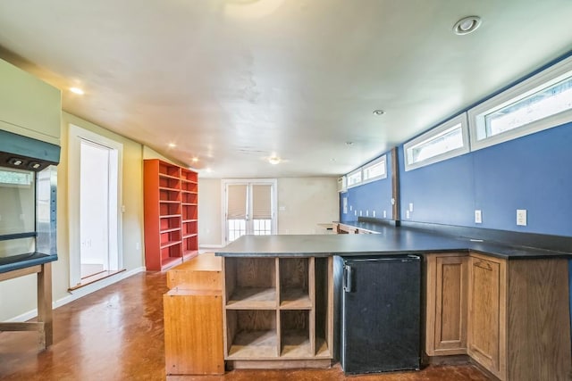 15102 Iowa St, Austin, TX 78734 - kitchen featuring dark countertops, brown cabinetry, recessed lighting, open shelves, and refrigerator