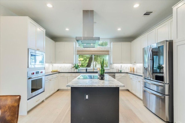 9110 Scotsman Dr, Austin, TX 78750 - kitchen featuring appliances with stainless steel finishes, island range hood, a center island, decorative backsplash, and recessed lighting