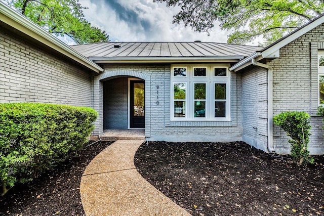 9110 Scotsman Dr, Austin, TX 78750 - view of exterior entry featuring a standing seam roof, brick siding, and a metal roof