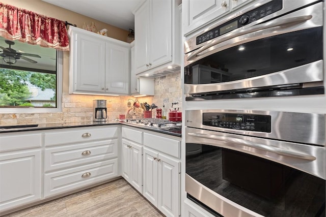 35 Forest Mesa, Round Rock, TX 78664 - kitchen featuring appliances with stainless steel finishes, backsplash, dark countertops, and white cabinetry