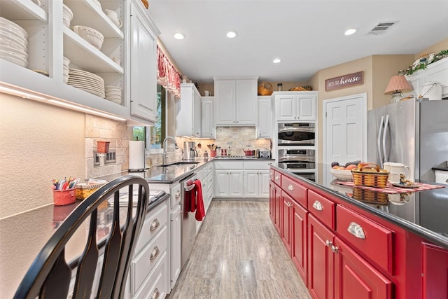 35 Forest Mesa, Round Rock, TX 78664 - kitchen with stainless steel appliances, recessed lighting, light wood-style flooring, decorative backsplash, and dark countertops