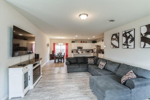 18430 Stevie Ray Dr, Round Rock, TX 78664 - living room with a chandelier and light wood-style floors