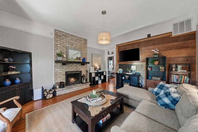 404 E 9th Ave, Belton, TX 76513 - living room featuring wooden walls, wood finished floors, and a brick fireplace