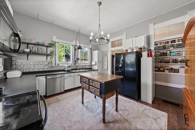 404 E 9th Ave, Belton, TX 76513 - kitchen featuring black appliances, dark countertops, light wood-type flooring, a chandelier, and backsplash