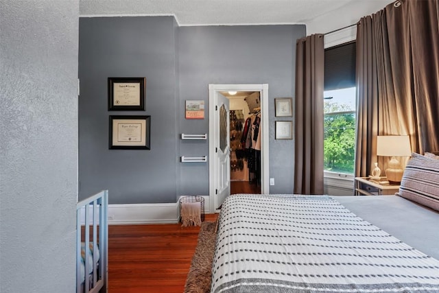 404 E 9th Ave, Belton, TX 76513 - bedroom with wood finished floors, a spacious closet, and a textured wall