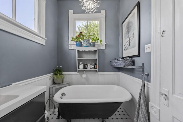 404 E 9th Ave, Belton, TX 76513 - bathroom with a soaking tub, a wainscoted wall, vanity, and a chandelier