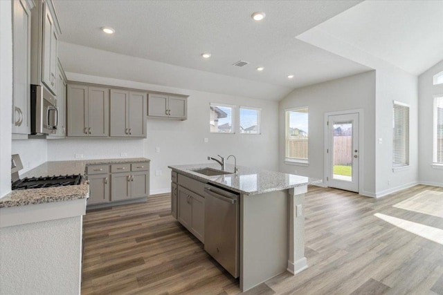 241 Snowbell St, San Marcos, TX 78666 - kitchen featuring appliances with stainless steel finishes, gray cabinetry, light wood-type flooring, lofted ceiling, and recessed lighting