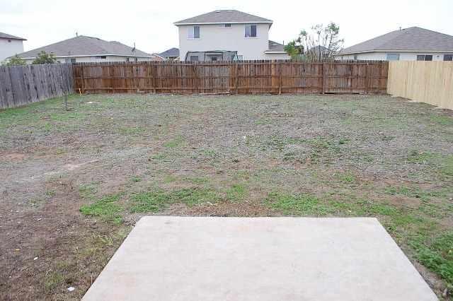 205 E Mitchell Dr, Hutto, TX 78634 - fenced backyard with a patio area
