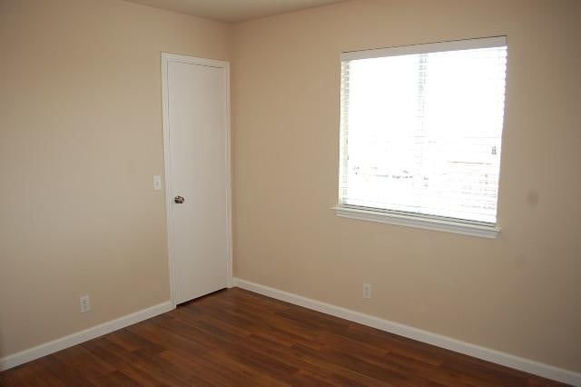 205 E Mitchell Dr, Hutto, TX 78634 - spare room with baseboards and dark wood finished floors