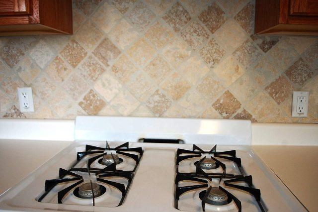 205 E Mitchell Dr, Hutto, TX 78634 - kitchen view of cooktop and brown cabinets