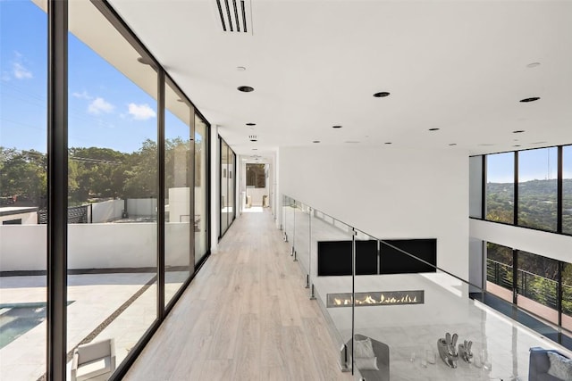 1501 Ridgecrest Dr, Austin, TX 78746 - hallway featuring expansive windows and light wood-style flooring