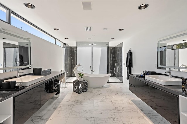 1501 Ridgecrest Dr, Austin, TX 78746 - full bathroom featuring a freestanding bath, two vanities, marble finish flooring, a walk in shower, and recessed lighting
