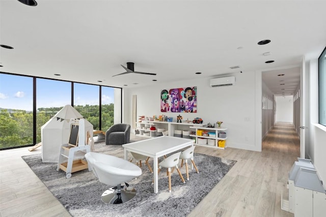 1501 Ridgecrest Dr, Austin, TX 78746 - game room with a wall mounted air conditioner, light wood finished floors, a wall of windows, and a ceiling fan