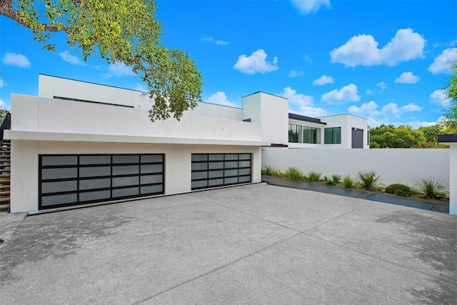 1501 Ridgecrest Dr, Austin, TX 78746 - modern home featuring stucco siding, a garage, stairway, and driveway