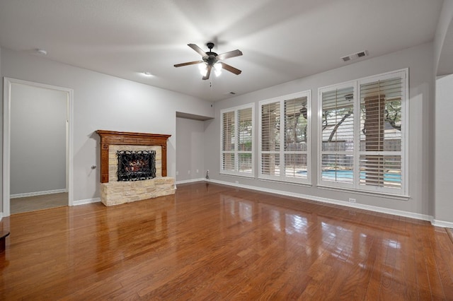 1116 Castle Path, Round Rock, TX 78681 - unfurnished living room featuring plenty of natural light, ceiling fan, a stone fireplace, and wood finished floors