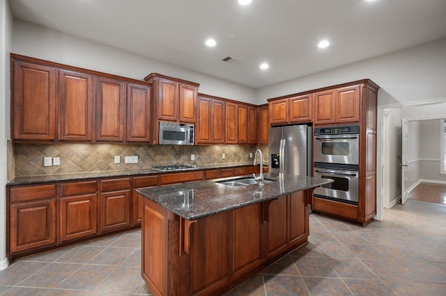 1116 Castle Path, Round Rock, TX 78681 - kitchen featuring stainless steel appliances, tasteful backsplash, a kitchen island with sink, dark stone countertops, and recessed lighting
