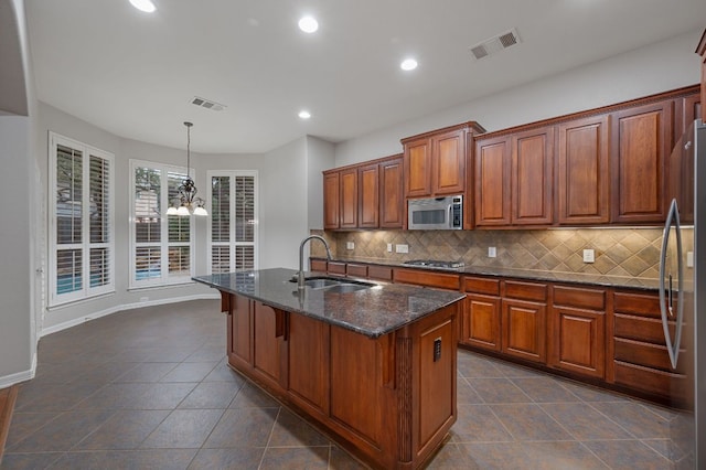 1116 Castle Path, Round Rock, TX 78681 - kitchen with stainless steel appliances, recessed lighting, tasteful backsplash, dark tile patterned floors, and dark stone countertops