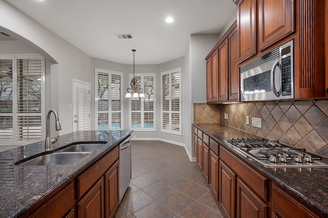 1116 Castle Path, Round Rock, TX 78681 - kitchen featuring stainless steel appliances, decorative backsplash, dark stone countertops, arched walkways, and recessed lighting