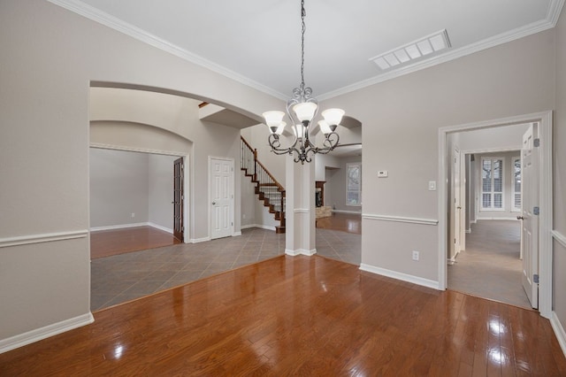 1116 Castle Path, Round Rock, TX 78681 - spare room featuring arched walkways, a chandelier, crown molding, wood finished floors, and stairs