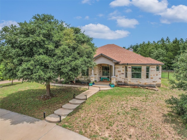 167 Manawianui Dr, Bastrop, TX 78602 - view of front of house featuring stone siding, covered porch, a front lawn, and a chimney