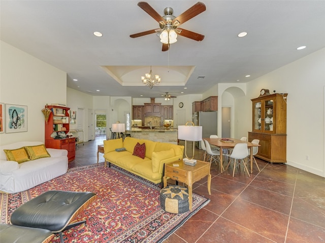 167 Manawianui Dr, Bastrop, TX 78602 - living room featuring arched walkways, a ceiling fan, a raised ceiling, a chandelier, and recessed lighting