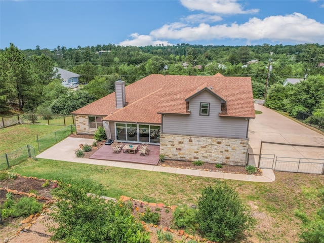 167 Manawianui Dr, Bastrop, TX 78602 - back of house with stone siding, a patio area, a chimney, a fenced backyard, and a shingled roof