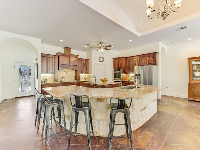 167 Manawianui Dr, Bastrop, TX 78602 - kitchen featuring stainless steel appliances, a spacious island, arched walkways, recessed lighting, and a kitchen breakfast bar