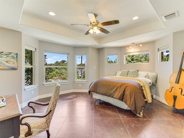 167 Manawianui Dr, Bastrop, TX 78602 - bedroom featuring a raised ceiling, multiple windows, a ceiling fan, dark tile patterned floors, and recessed lighting