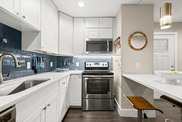 935 La Posada Dr Unit 148, Austin, TX 78752 - kitchen featuring stainless steel appliances, white cabinetry, dark wood-type flooring, tasteful backsplash, and recessed lighting