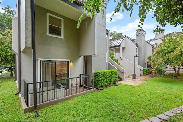 935 La Posada Dr Unit 148, Austin, TX 78752 - rear view of property with a yard, stucco siding, and a patio