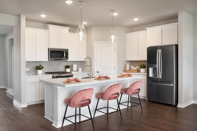 1425 Purple Martin Dr, Pflugerville, TX 78660 - kitchen featuring stainless steel appliances, decorative backsplash, light countertops, white cabinets, and dark wood-style flooring